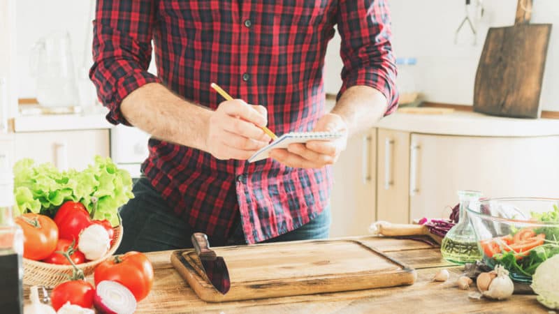 man-taking-notes-in-kitchen-800×450